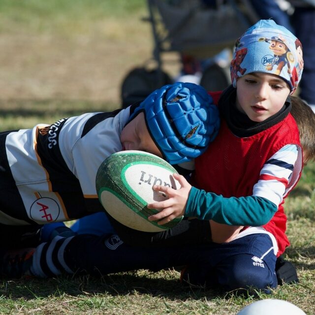 Dos niños disputan un balón de rugby Kauri en una escuela de rugby